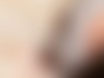 Closeup of beige corset with vertical boning and white lacing on a dress form.