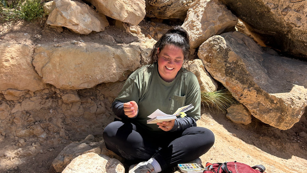Mariah smiling and looking at her journal.