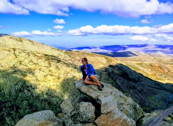 Woman hiker on the top of a mountain peak