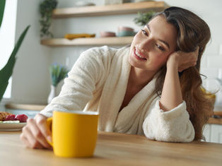 Woman enjoying a calm morning moment with coffee, reflecting a simple self-love morning routine for confidence and emotional well-being.
