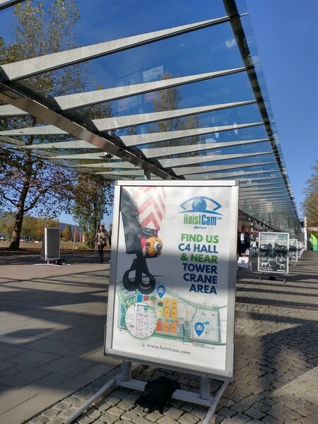 Ad stand for HoistCam showing a camera on a crane hook and a map to their location at C4 Hall.