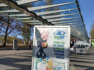 Ad stand for HoistCam showing a camera on a crane hook and a map to their location at C4 Hall.