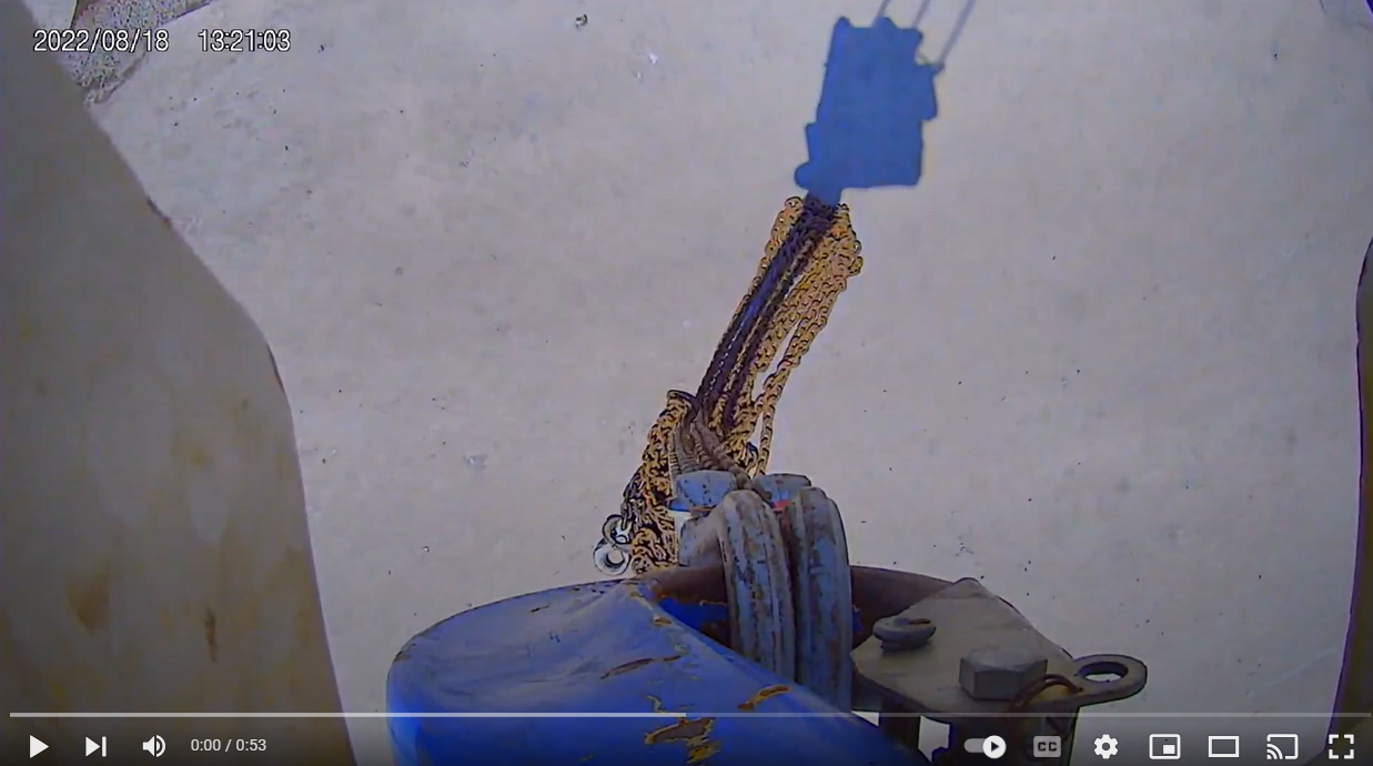 View from a HoistCam camera attached to a crane's hook block, showing chains connected below it.
