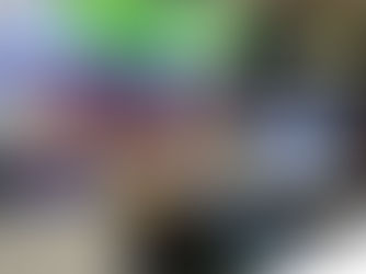  A man with a beard stands behind a table displaying HoistCam equipment at a trade show. A banner behind him reads "EVERY LOAD ON POINT." The table features a yellow camera system, tablets, and a monitor.