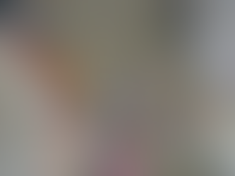 Overhead view of a construction site with workers in hard hats; one pulls a rope near a large pipe. Palette and gravel in the background.