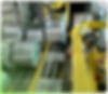 Metal rolls move along a conveyor in an industrial facility.