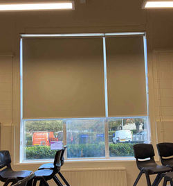 Cream roller blinds in office