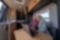 Vibrant senior couple eating breakfast in their camper van
