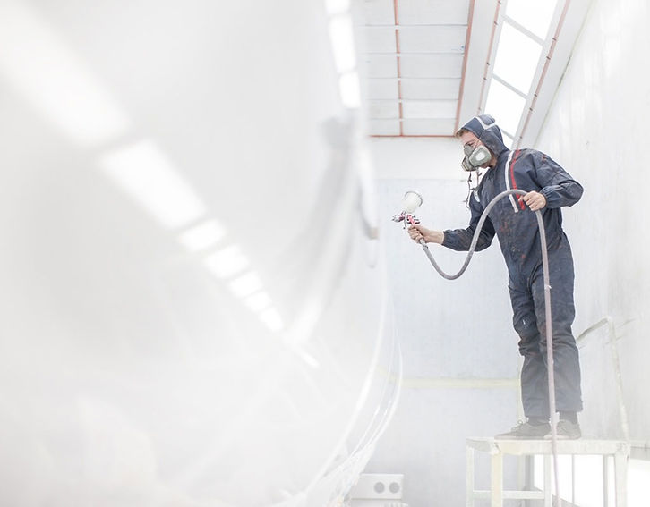 man in protective clothing spraying