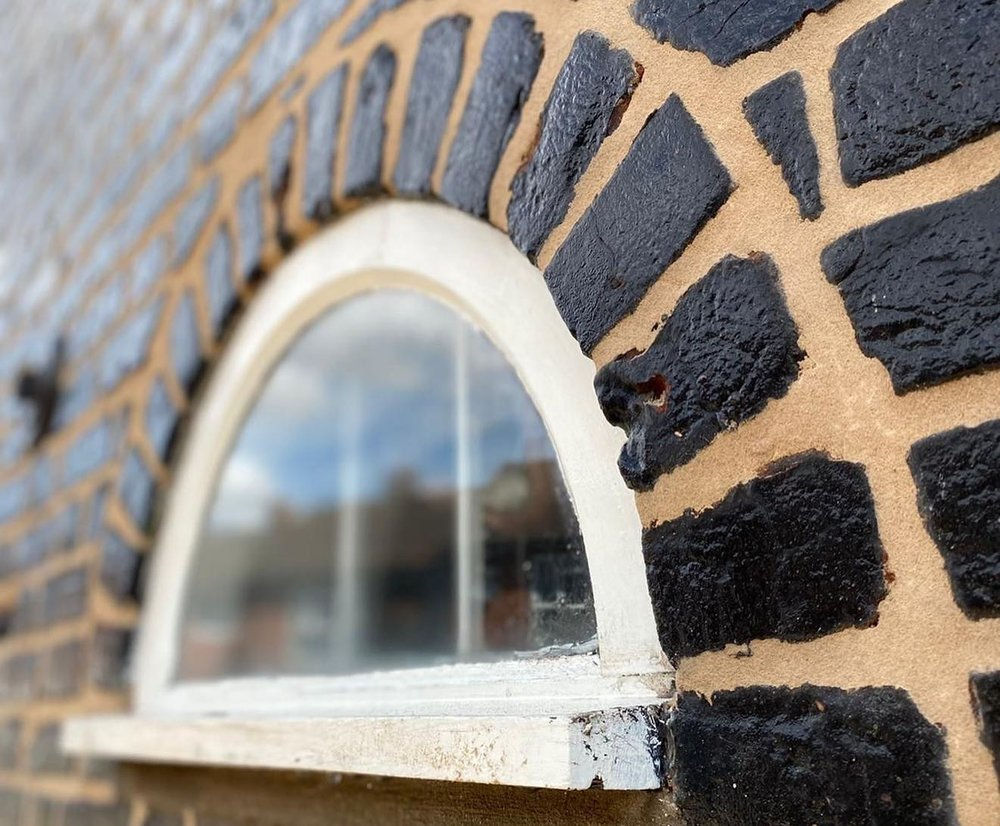 A closeup of newly installed black bricks on the side of a home