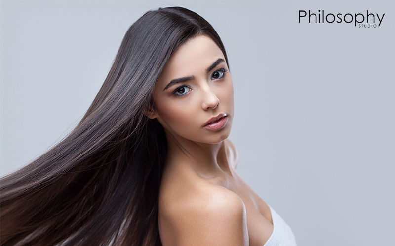 Woman showing off her shiny, smooth, revitalized hair.