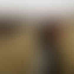 Man holding woman as they share a passionate kiss, set against a serene mountain backdrop.