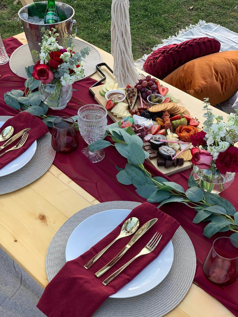 Close-up of the Romance Me picnic setup with romantic red and burgundy decor by Sunkissed Design & Co.