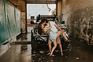 Couple having a candid moment in a carwash, photographed by Abby Machacek Photography.