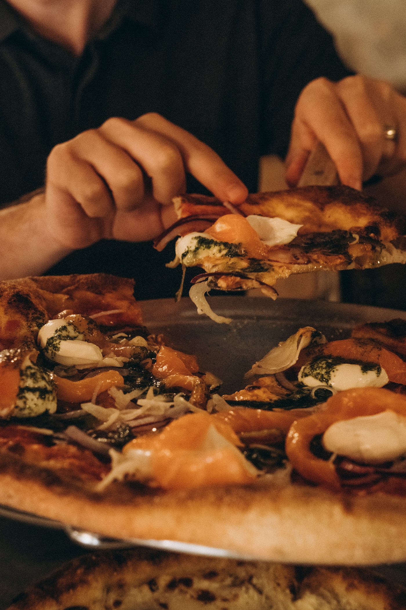 Een versgebakken pizza in de hand
