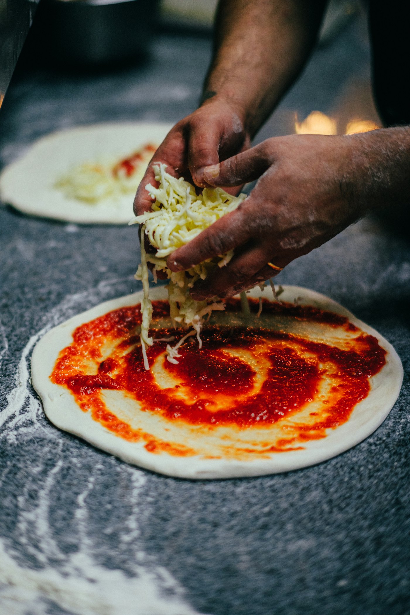 Tomatensaus op de pizza smeren