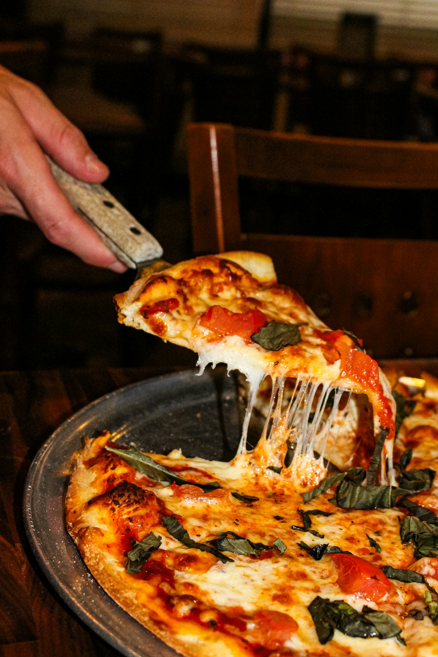 Een punt pizza met gesmolten kaas