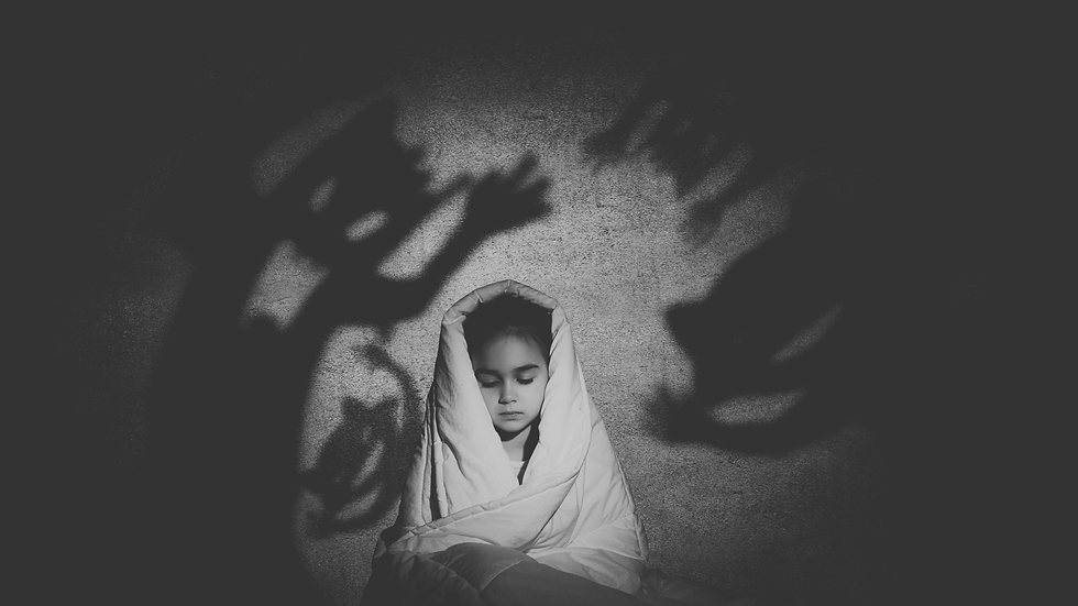 Sad child wrapped in a blanket with  creepy shadow hands around