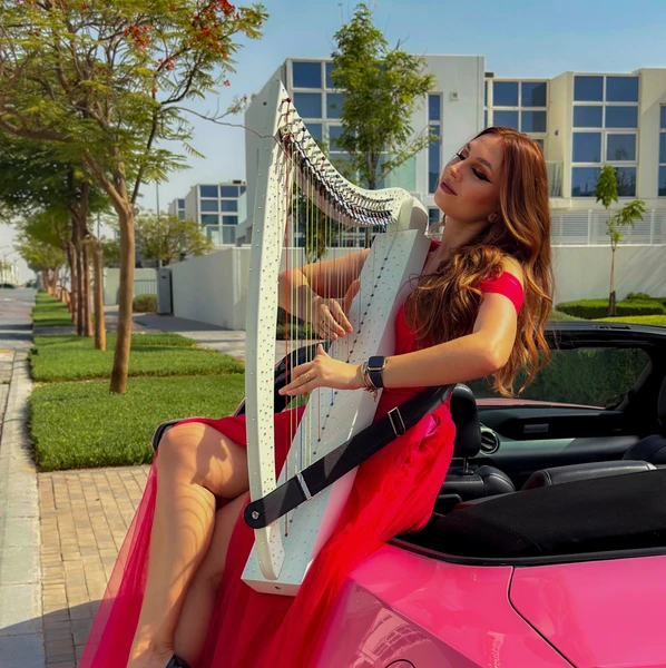 White roaming harp performance by professional Dubai harpist Slavrada at a luxury wedding, corporate event or private celebration in Dubai.