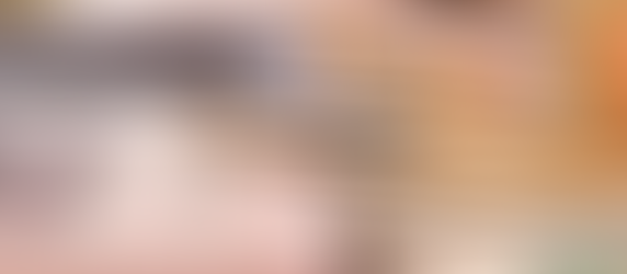 Calculator and gold pen on US dollar bills, with stacked coins in the background, convey financial and business themes.