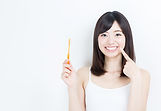 歯ブラシを手に持って歯を強調する女性