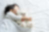 ぬいぐるみを抱えて眠る子