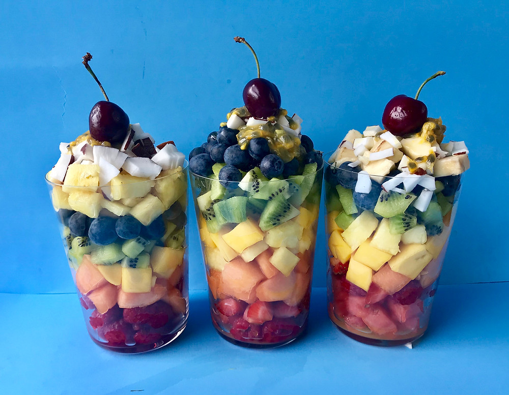 Healthy fruit sundae made with rainbow fruit including melon, pineapple, kiwi and coconut. Don't forget the cherry on top!