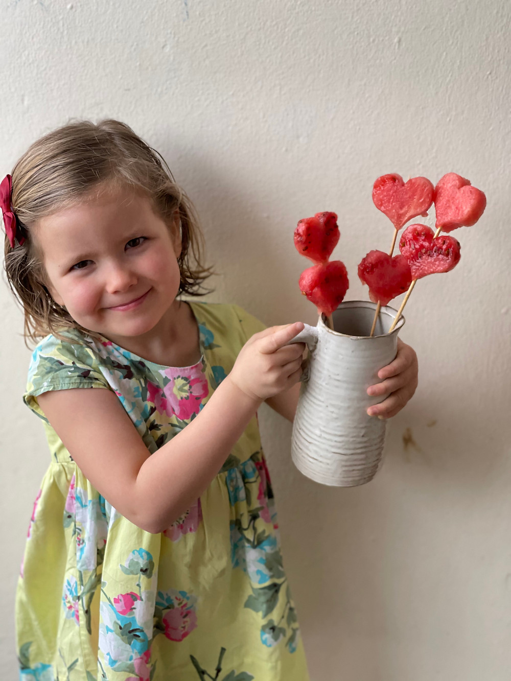 Claudine Boulstridge's daughter holding healthy watermelon hearts on a stick