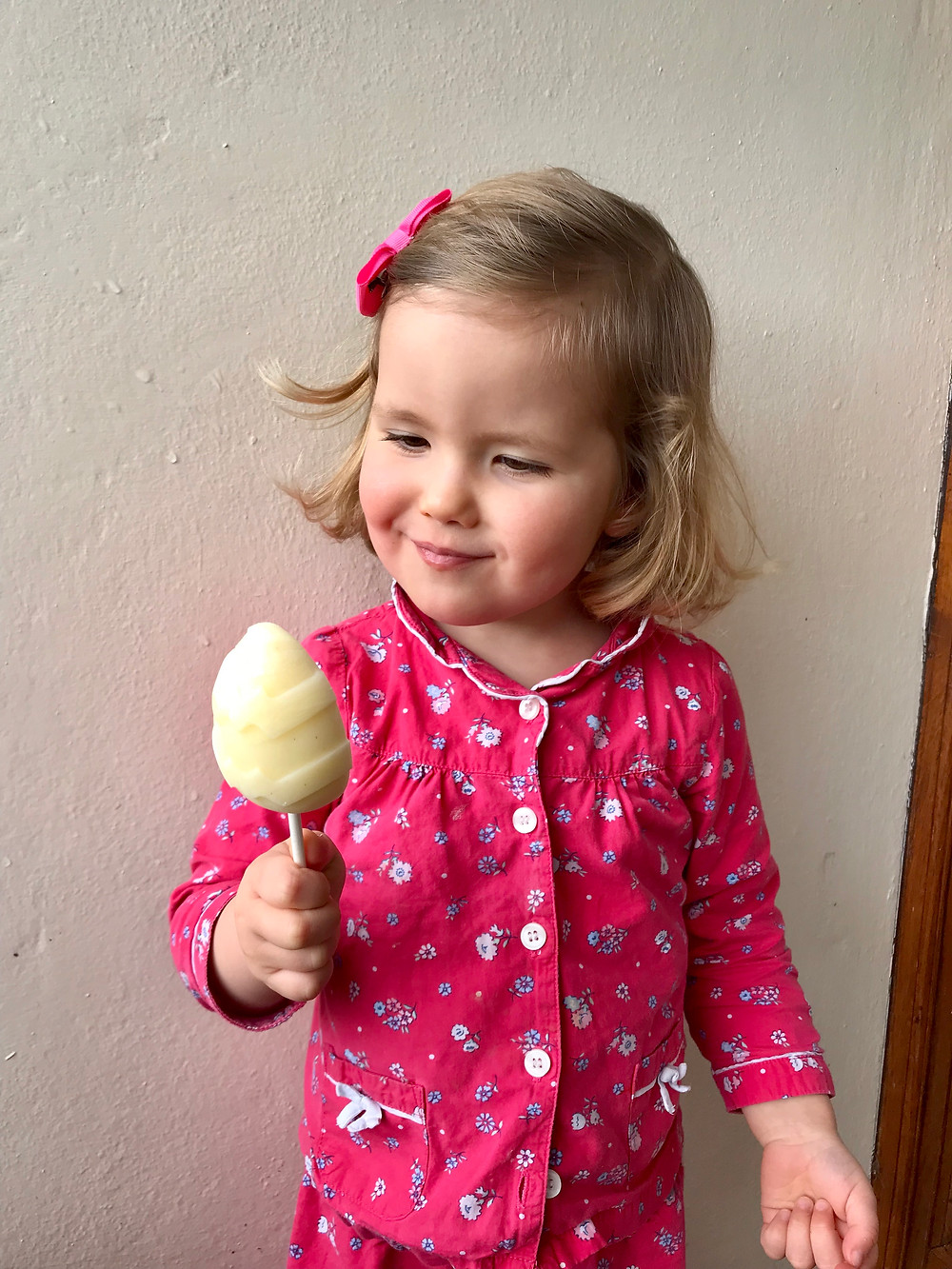 Claudine Boulstridge's young daughter in her pyjamas eating an Easter egg-shaped healthy ice-cream lolly