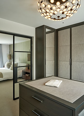Walk-in wardrobe with bespoke cabinetry, island storage and statement lighting, luxury dressing room