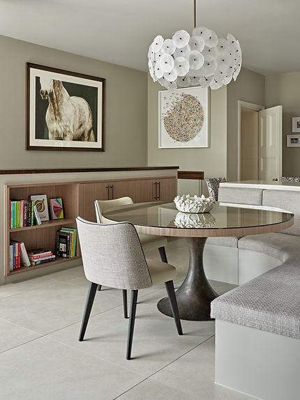 Kitchen island with upholstered bar stools and bespoke cabinetry in a luxury open-plan space