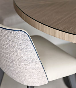 Dining chair detail with tailored upholstery and contrast piping in a luxury interior