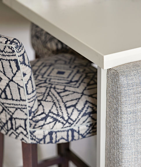 Dining chair detail with tailored upholstery and contrast piping in a luxury interior