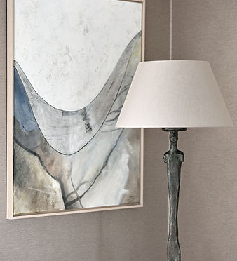 Table lamp and abstract artwork styled against textured wall creating a refined interior vignette
