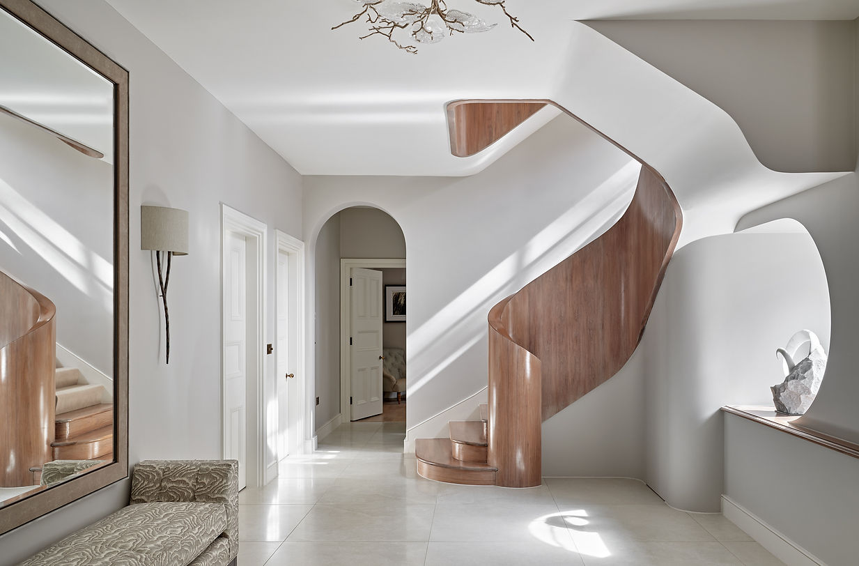 Entrance hall with sculptural curved staircase showcasing bespoke architectural design