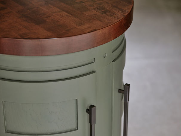 Bespoke kitchen island detail with curved cabinetry, timber worktop and painted finish, luxury interior design
