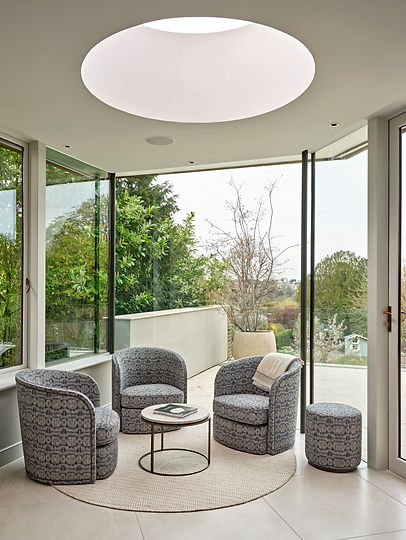 Garden room seating area with panoramic glazing enhancing light and indoor-outdoor living