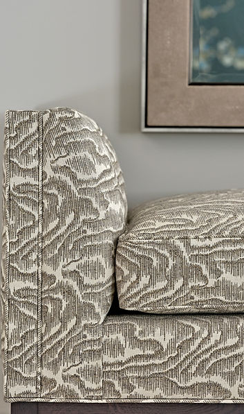 Upholstered bench with textured fabric adding subtle pattern and comfort to a luxury interior
