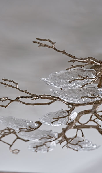 Decorative chandelier detail with glass leaves adding sculptural elegance to a luxury interior