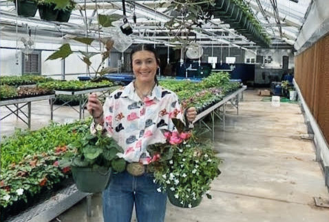 Dublin FFA student Jena Sorrells shows off a couple of hanging baskets inside the high school's new greenhouse. Photos/Sophie Hayhurst