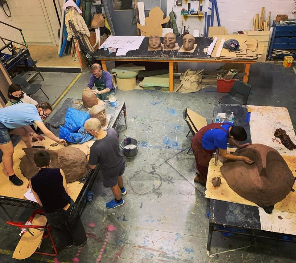 Participants and artists work together in the Northern Stage workshop to build masks and puppets out of cardboard and clay