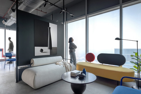 Modern office waiting room with large window and stylish furniture.