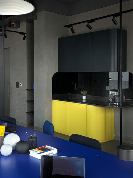 Modern kitchen with yellow cabinets and dark accents.