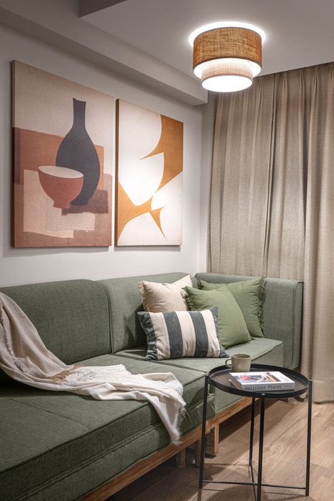 Cozy living room with abstract art and green sofa.