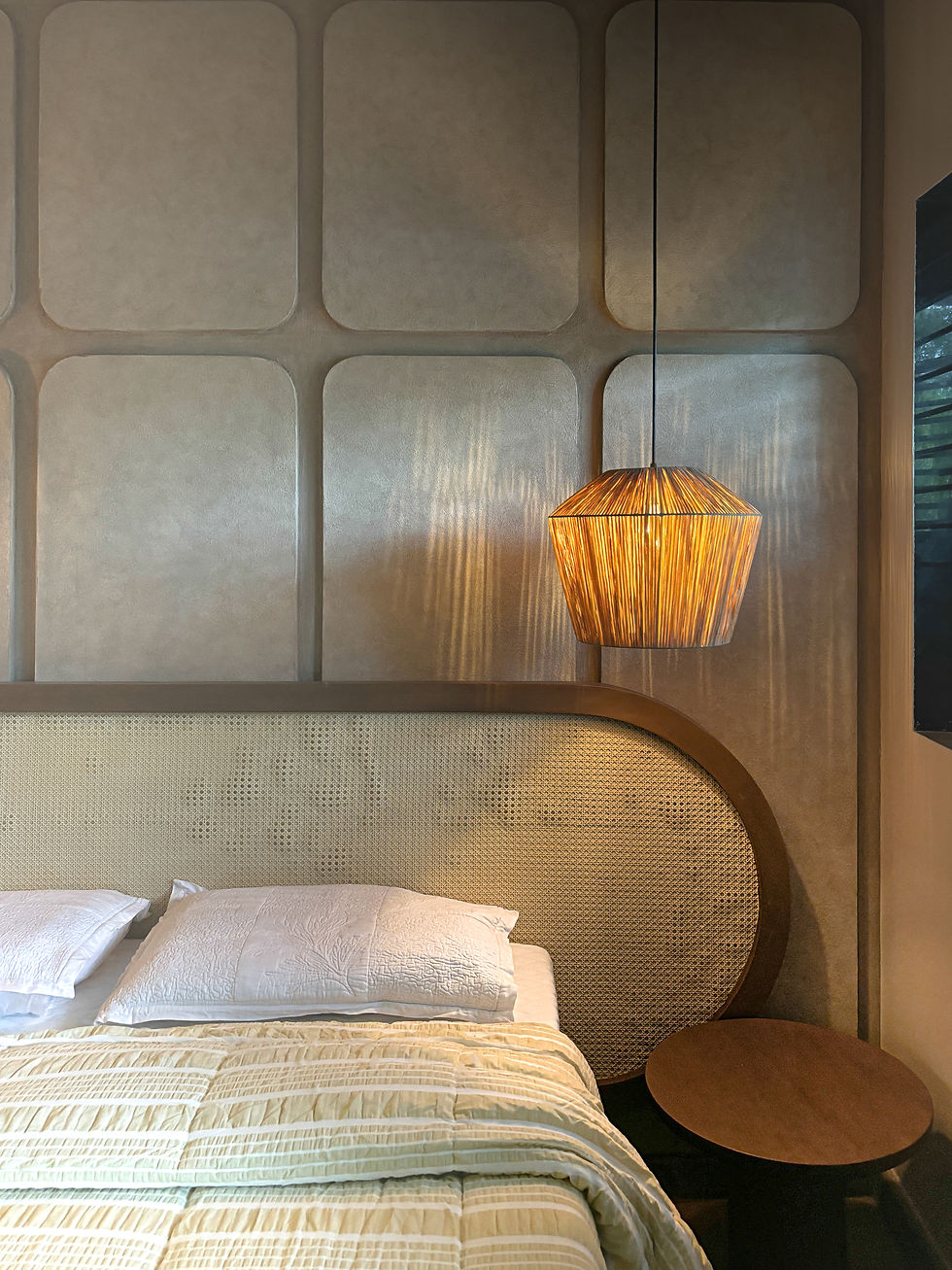 Warm modern bedroom with white bed, woven headboard, glowing pendant lamp, and textured beige wall panels