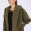 Thumbnail: Woman wearing a Nordic Beach Wrap Jacket in  Olive U , with black tee shirt