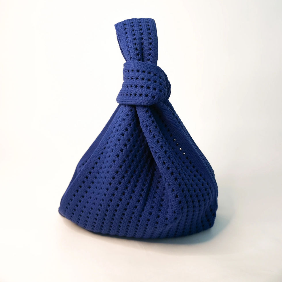 Navy crochet knit handbag by A Bag Concept featuring a knotted top handle and lightweight, machine-washable design.