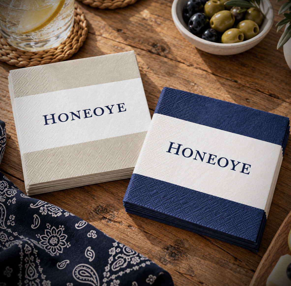 Honeoye Lake cocktail napkins in navy and natural stripes styled with a bandana napkin and light refreshments on a weathered
