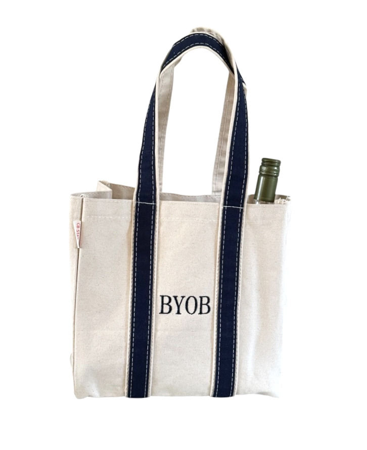 Natural canvas BYOB wine carrier with navy straps and embroidered lettering