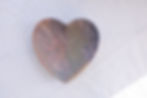 Hand-carved heart-shaped soapstone dish in natural marbled stone with white background